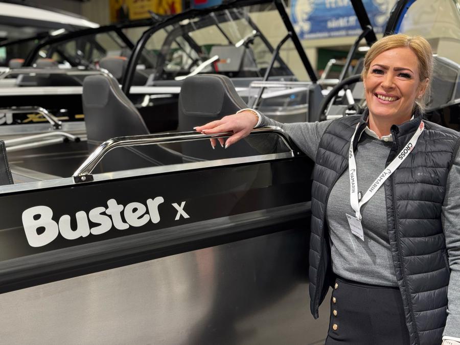 Wicmarinen myymäläpäällikkö Victoria Berg nojailee iloisena Buster X -veneeseen.