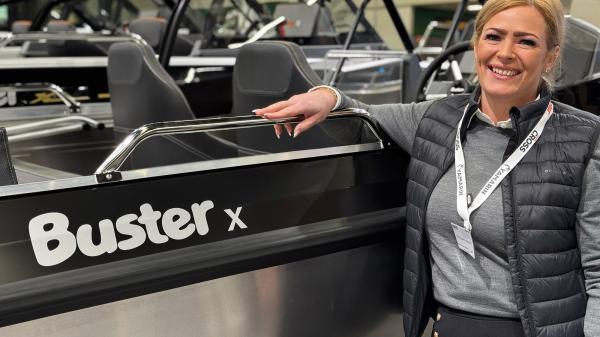 Wicmarinen myymäläpäällikkö Victoria Berg nojailee iloisena Buster X -veneeseen.