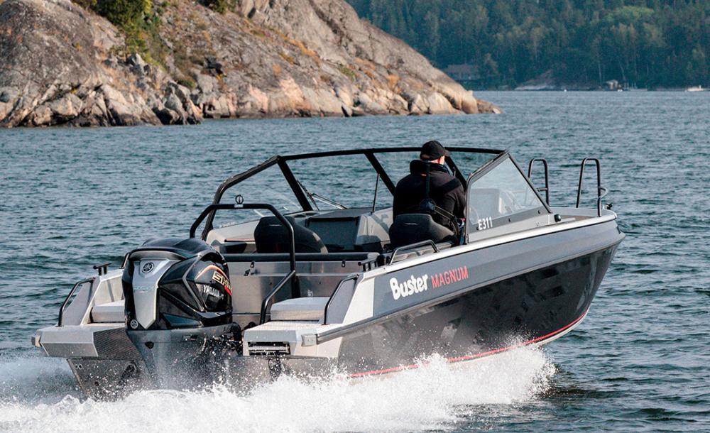 Buster Magnum VMAX on a lake, driving towards northeast. There is a rock formation and some trees in the background.